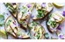 Toastsmörgås med avokadoröra, majonäs, skivad halloumi och ljust lila blomblad. Foto taget uppifrån.